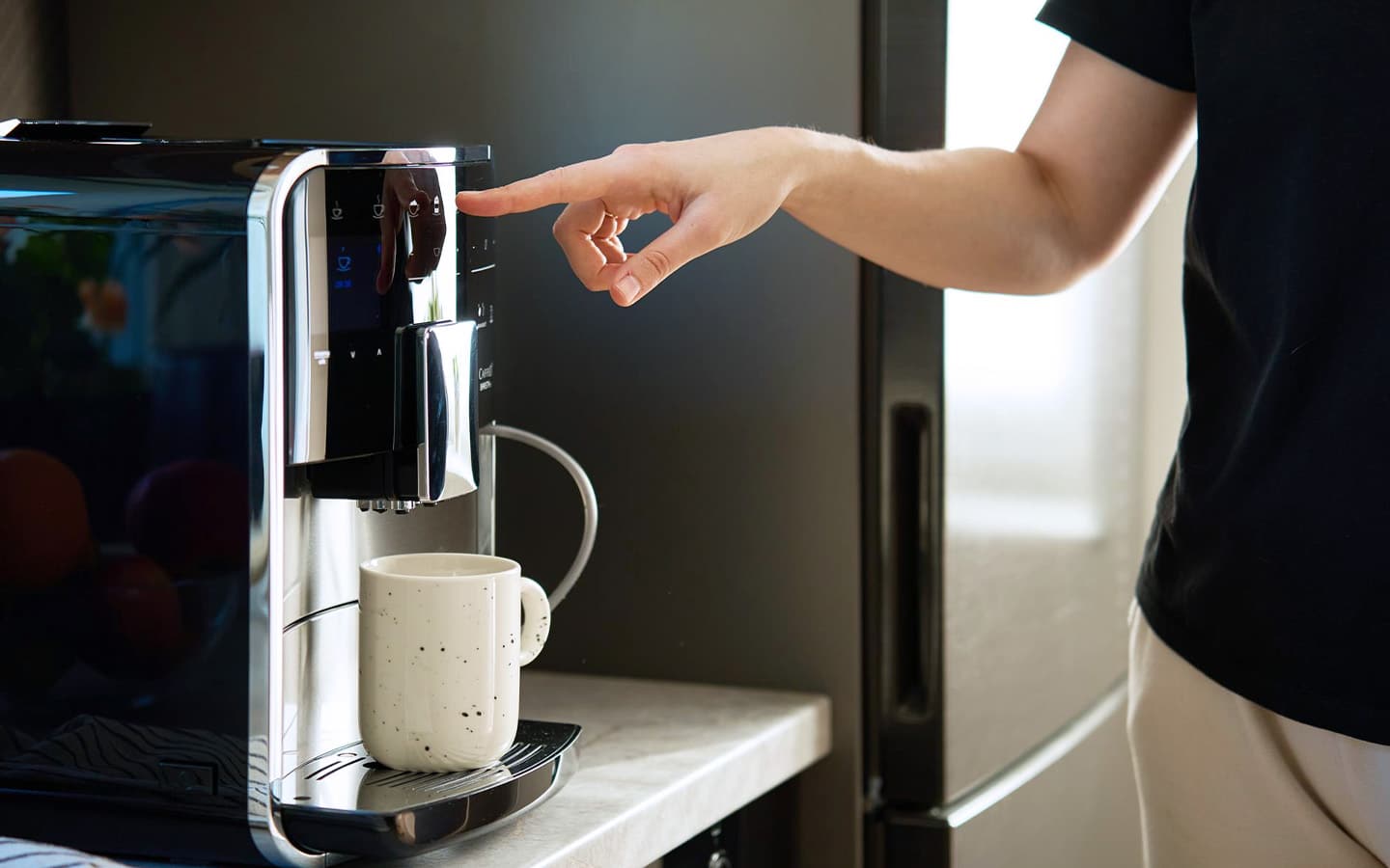 Man drukt op knop van kapotte koffiemachine die geen koffie meer geeft