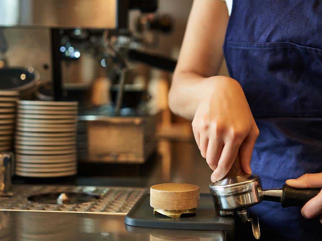 Tamperen-van-koffiebonen-in-filterdrager